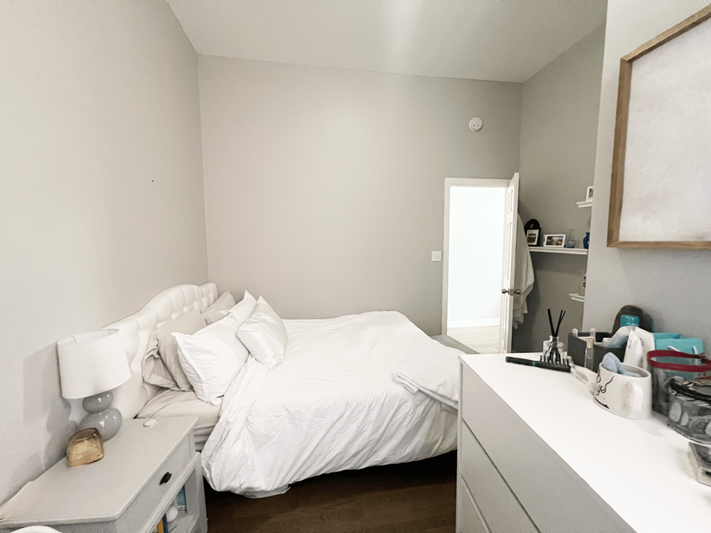 a small bedroom with a bed and a white comforter