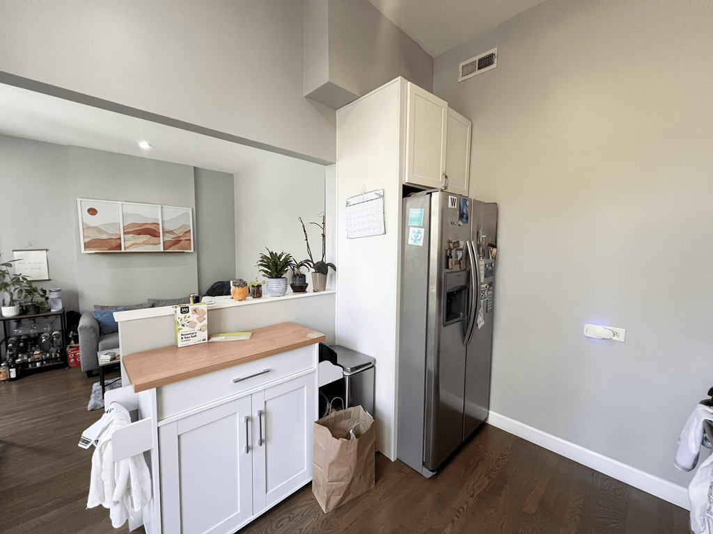 a kitchen with white cabinets and a stainless steel refrigerator