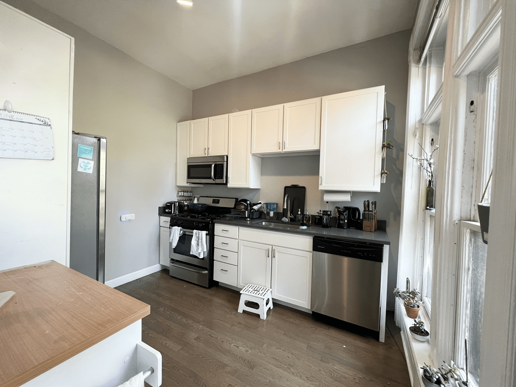 a kitchen with white cabinets and stainless steel appliances