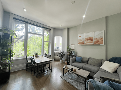 a living room with a large window and a dining room table
