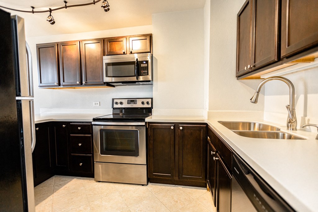 a kitchen with stainless steel appliances and wooden cabinets
