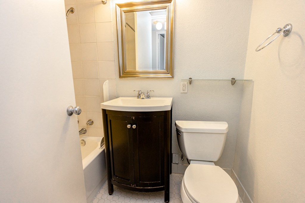a bathroom with a toilet and a sink and a bath tub