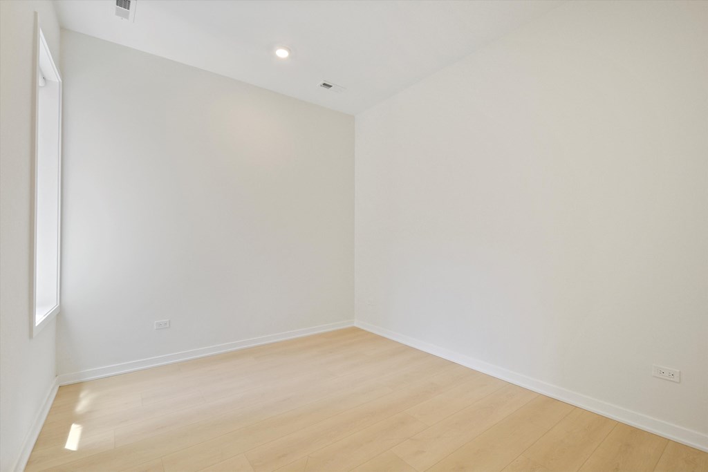 an empty room with white walls and a wooden floor