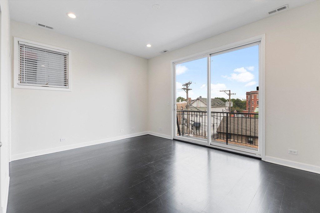 a bedroom with a large window and a balcony