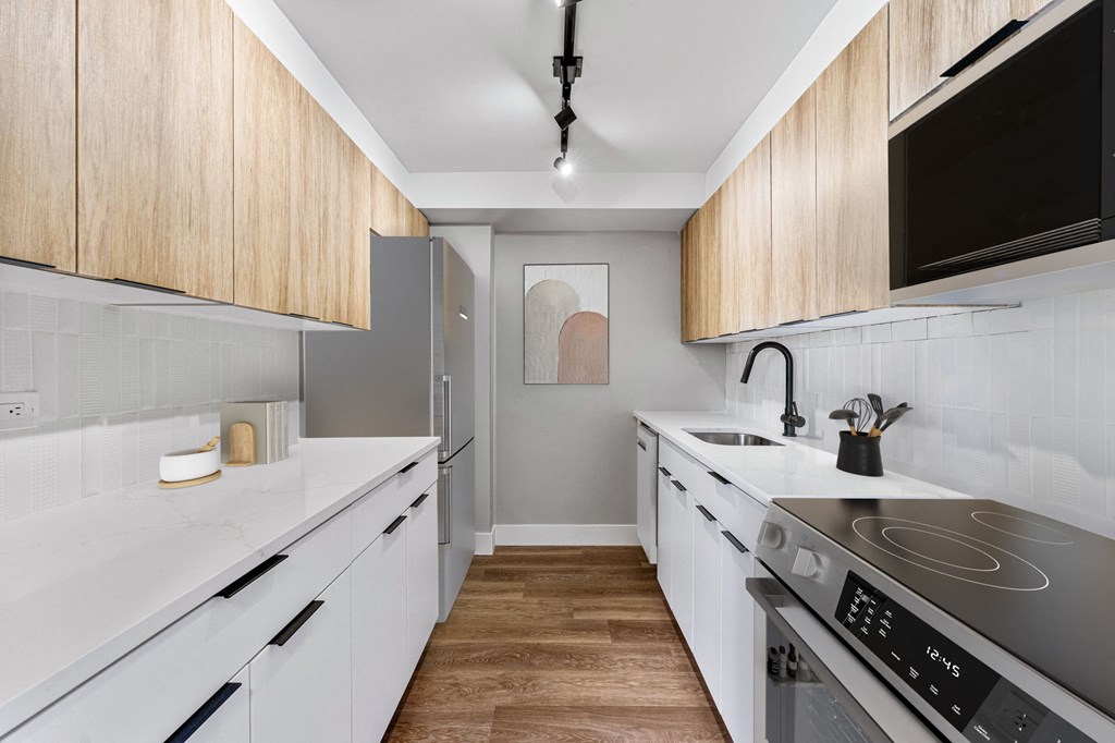 a kitchen with white counter tops and wooden cabinets