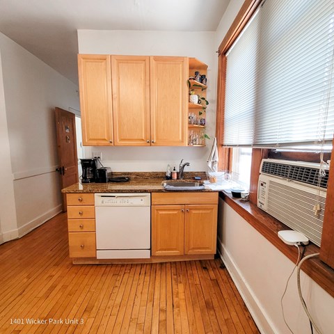 A kitchen with wooden cabinets and a white dishwasher.