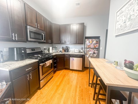 A kitchen with dark wood cabinets and a white fridge.