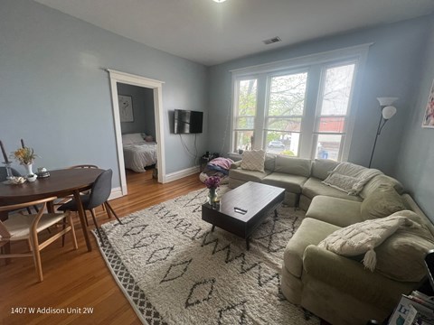 A living room with a couch, coffee table, and television.
