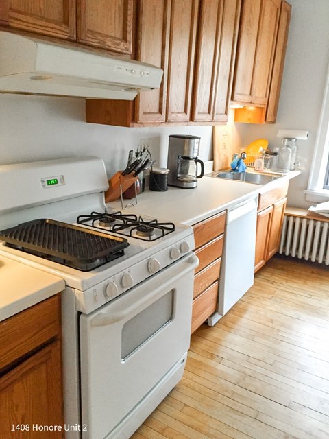 A kitchen with a white stove and wooden cabinets.