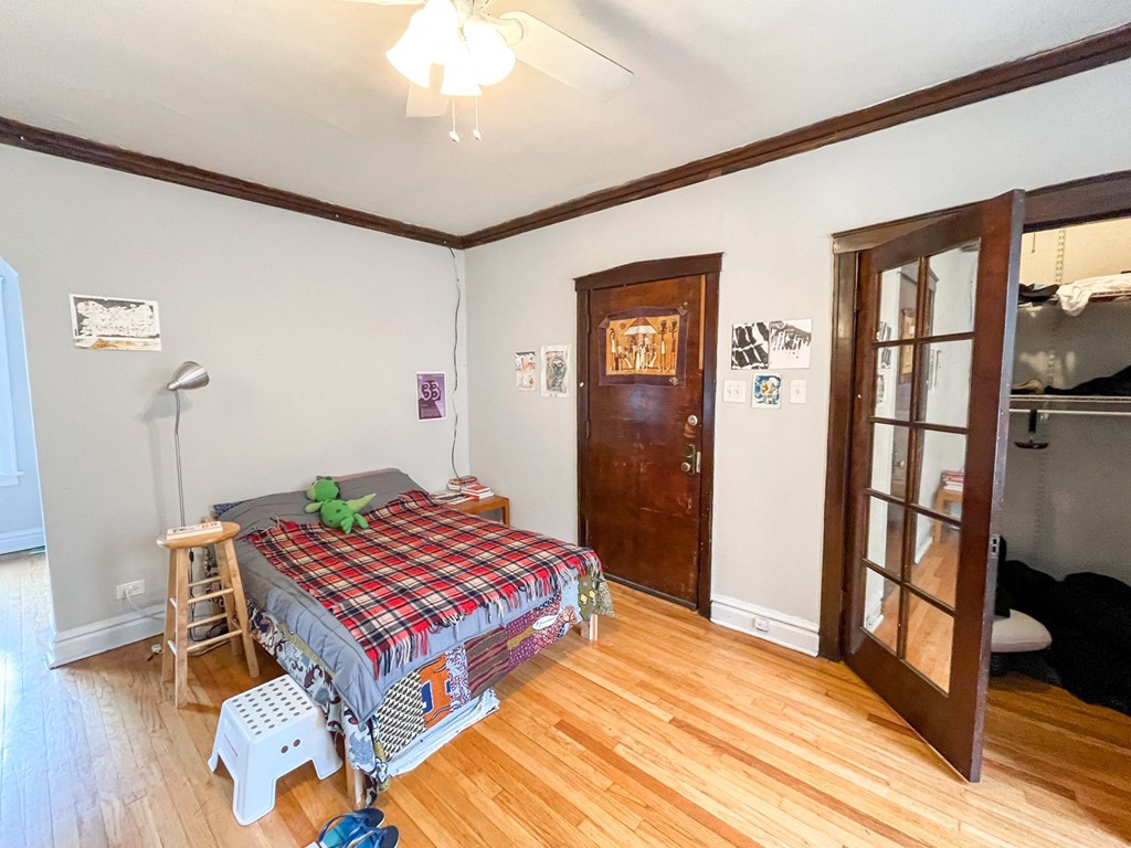 a bedroom with a bed and a wooden floor