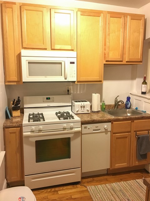 A kitchen with wooden cabinets and white appliances.