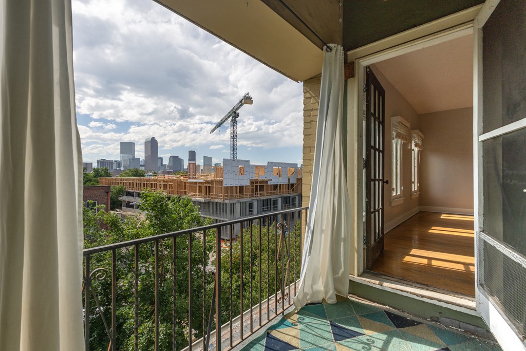 a balcony with a view of a city and a crane