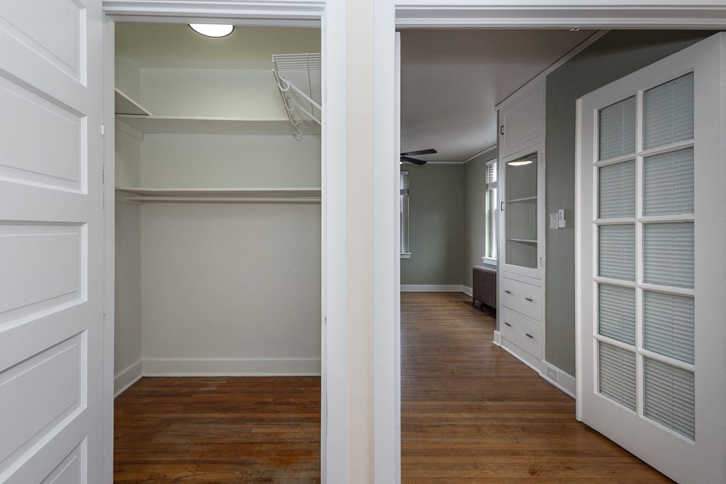 a hallway with white closet doors and a wood floor