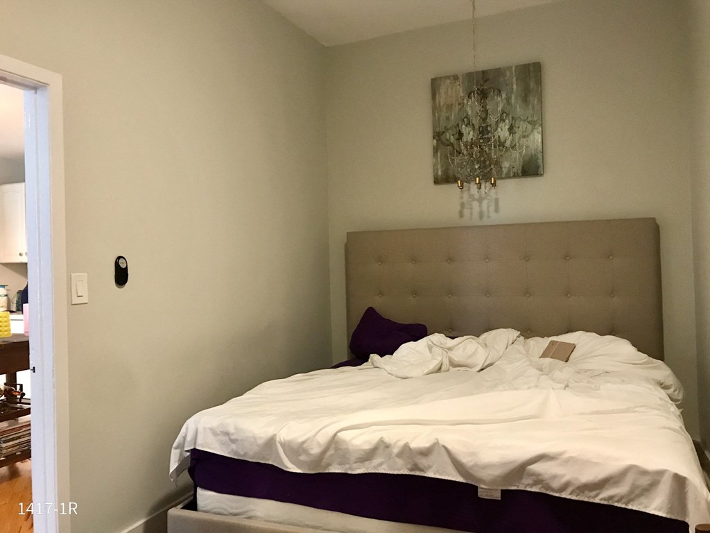 a bedroom with a bed and a chandelier