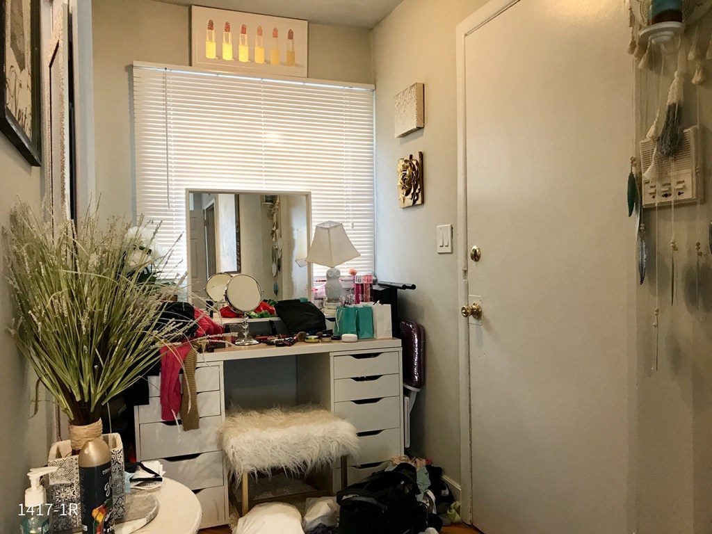 a cluttered room with a desk and a mirror