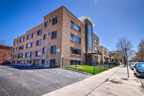 a brick apartment building on the corner of a street