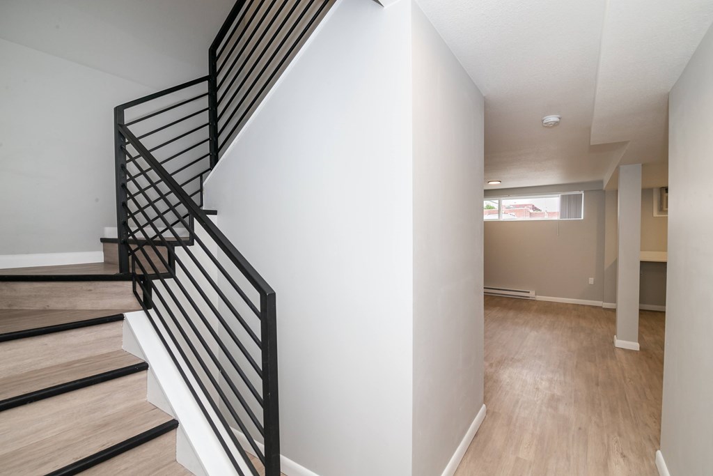 A staircase with a black metal railing and wooden steps.