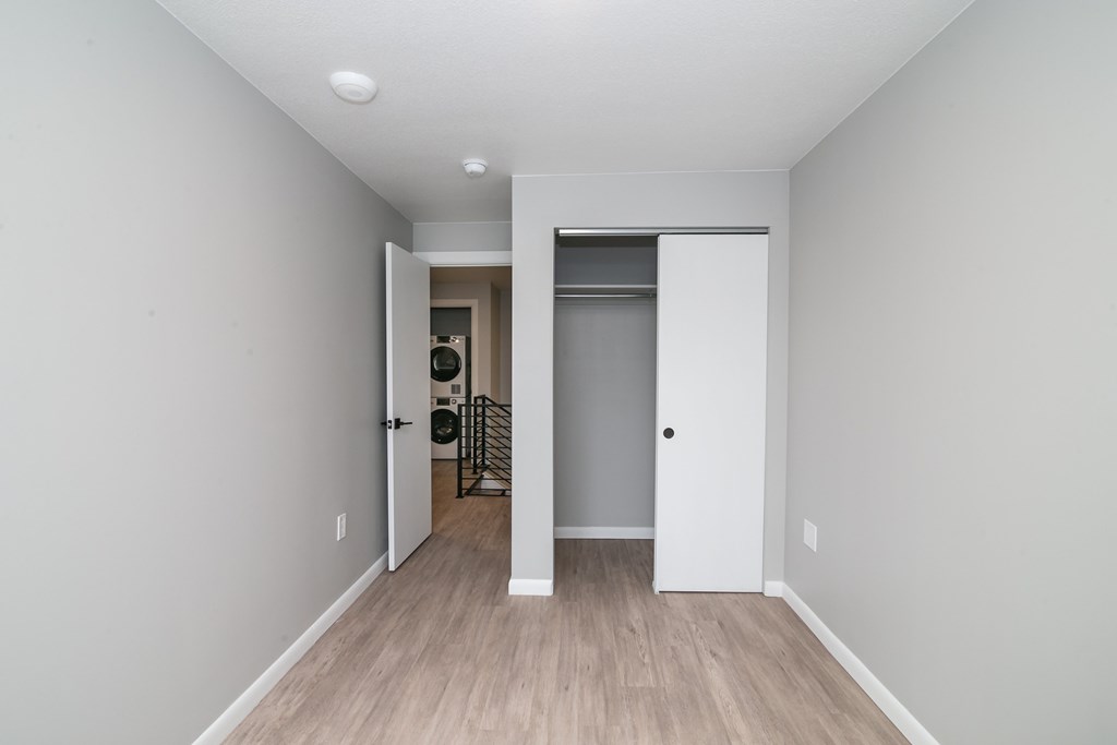 A white door is open to a hallway with a staircase.