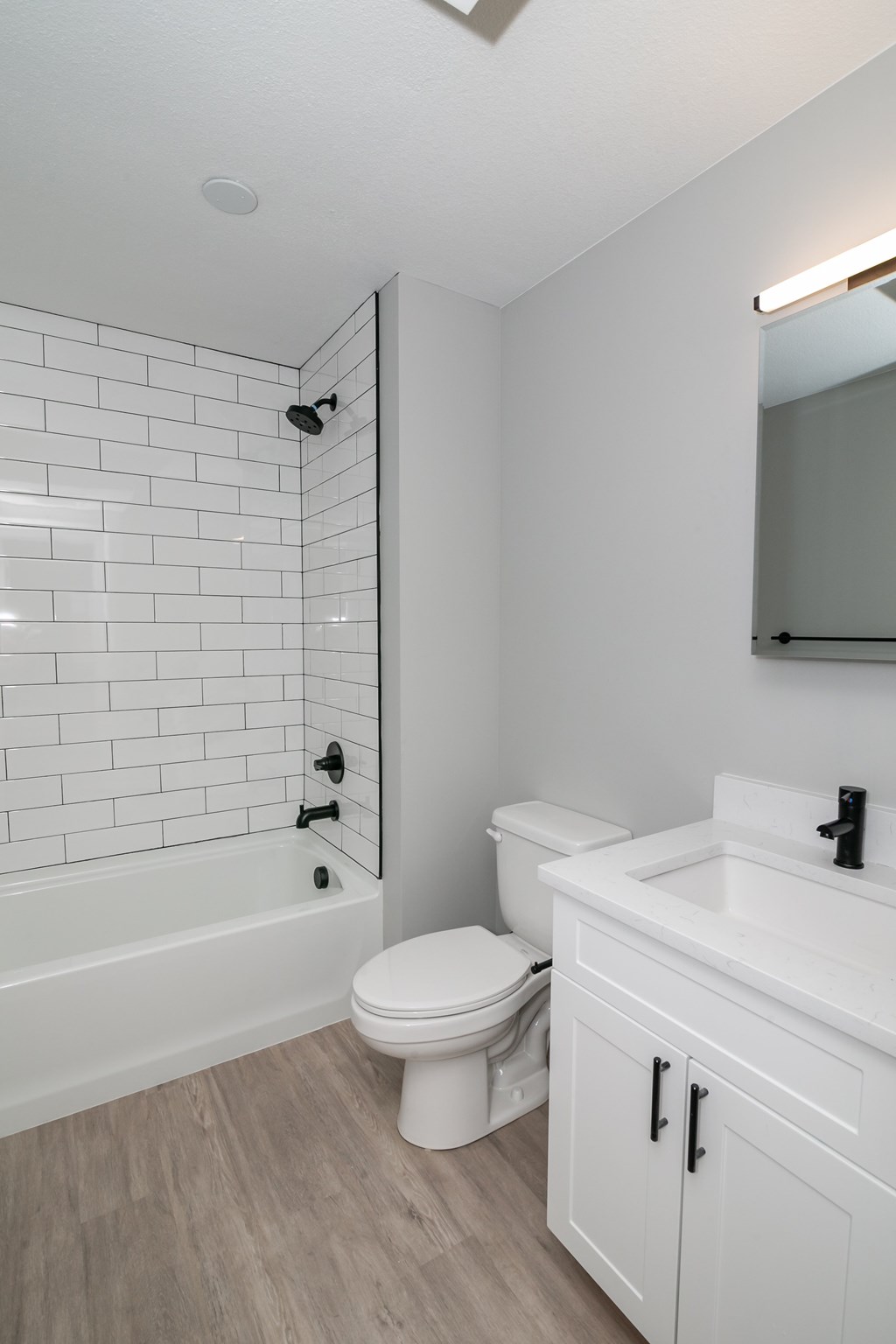 A white bathroom with a toilet, sink, and bathtub.