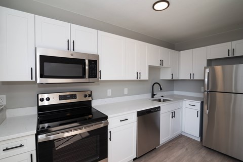 A kitchen with white cabinets and stainless steel appliances.