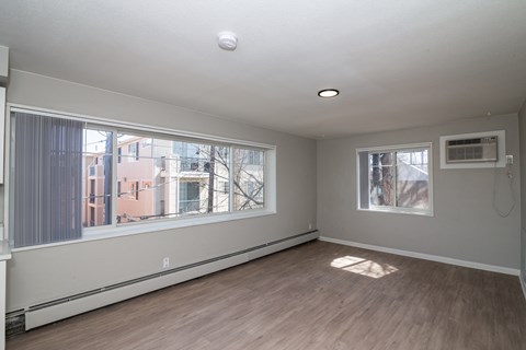 A room with a window and a wall-mounted air conditioner unit.