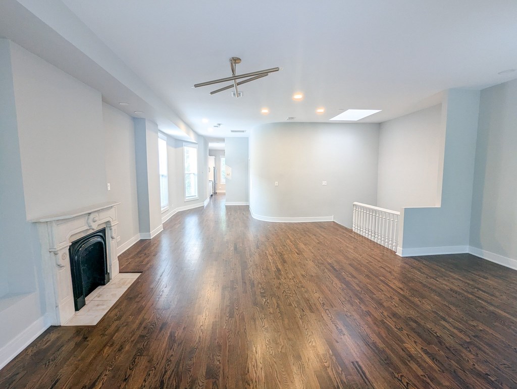 A room with a fireplace and wooden floors.