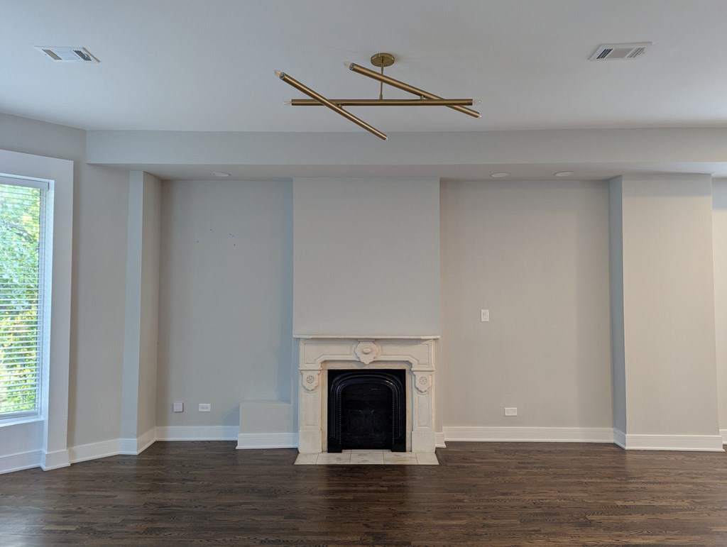 A living room with a fireplace and a ceiling fan.