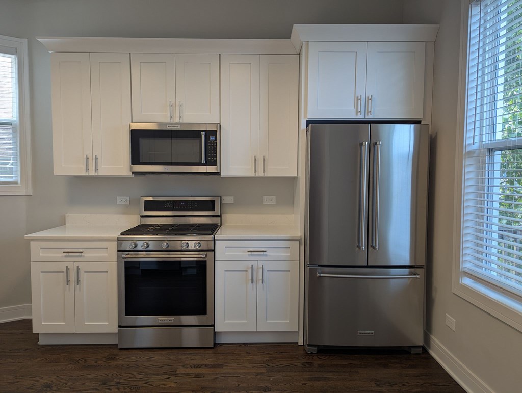 A kitchen with white cabinets and stainless steel appliances.
