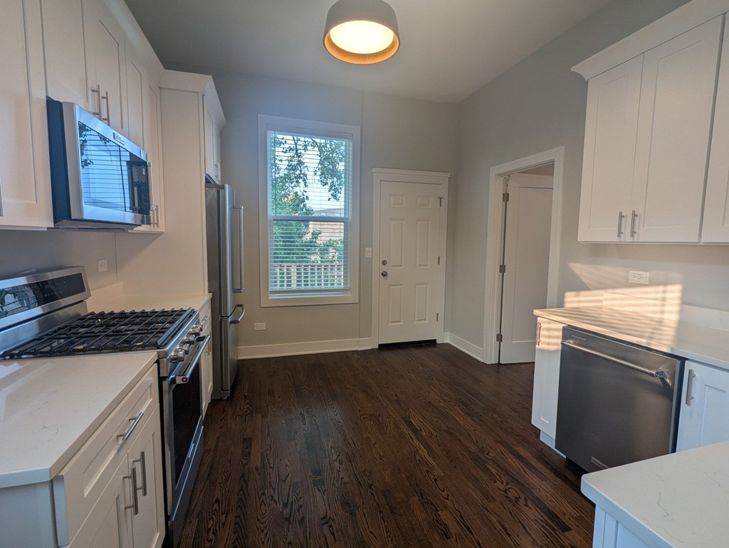 A kitchen with white cabinets and a black stove top.