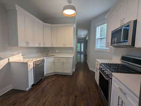 A kitchen with white cabinets and black appliances.