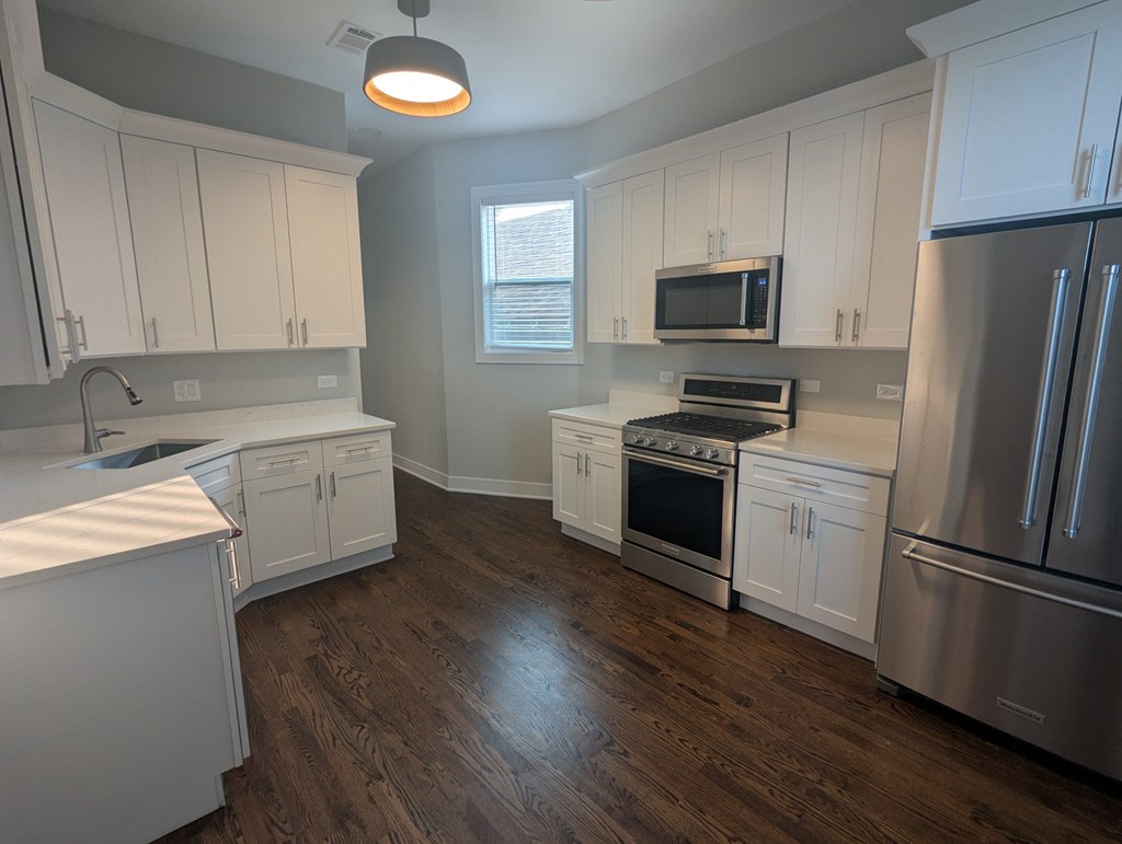 A kitchen with white cabinets and stainless steel appliances.