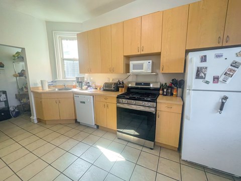 A kitchen with wooden cabinets and a white refrigerator.