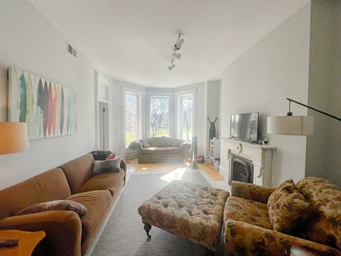 A living room with a brown couch and a fireplace.