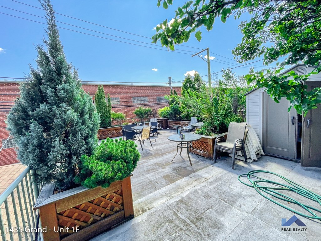 a patio with a table and chairs and trees