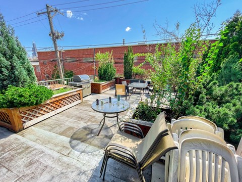 A patio with a table and chairs overlooking a brick wall.