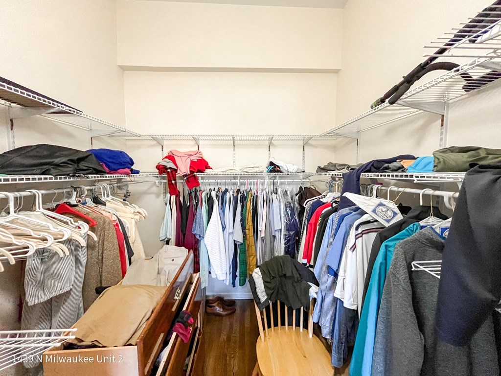 a closet filled with clothes and clothes hanging on a rack