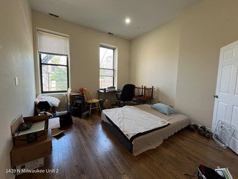 a bedroom with a bed and a desk and a window