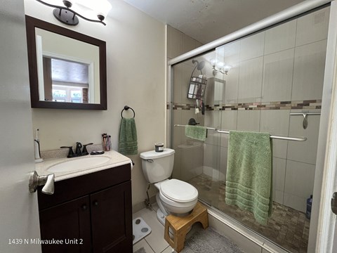 a bathroom with a shower toilet and sink and a mirror