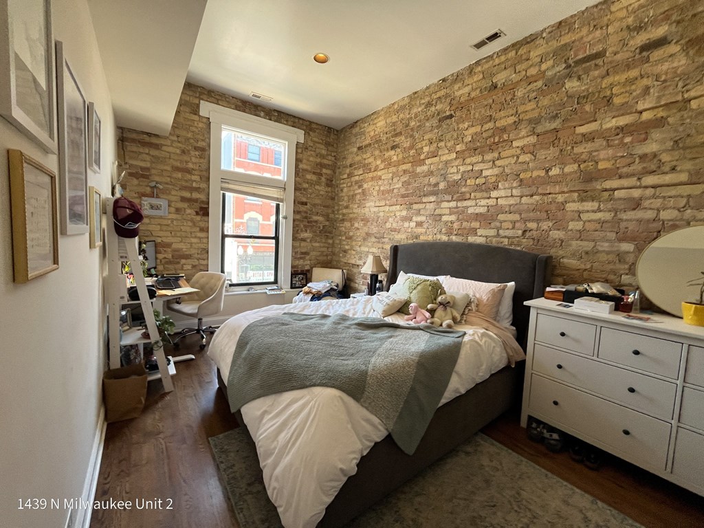a bedroom with a bed and an exposed brick wall