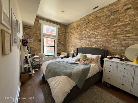 a bedroom with a bed and an exposed brick wall