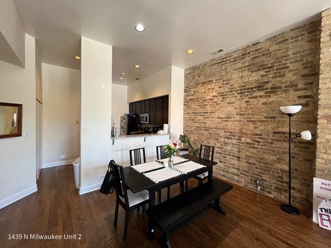 a dining room with a table and a brick wall