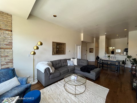 a living room with a gray couch and a glass coffee table