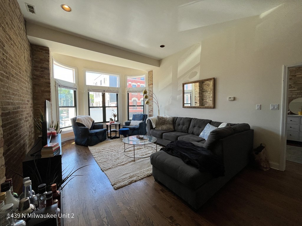 a living room with a couch and two chairs and a rug