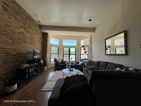 a living room with a brick wall and a couch and a table
