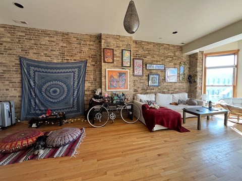 A living room with a brick wall and a bicycle.