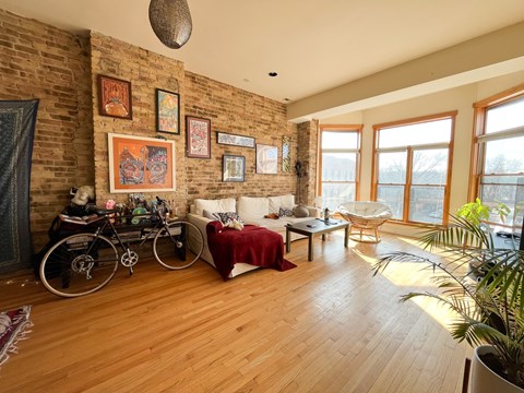 A living room with a brick wall and a bicycle.