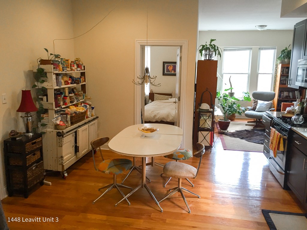 a dining room with a table and chairs and a bedroom with a bed