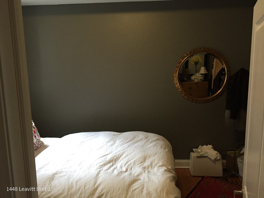 a bedroom with a bed and a mirror on the wall