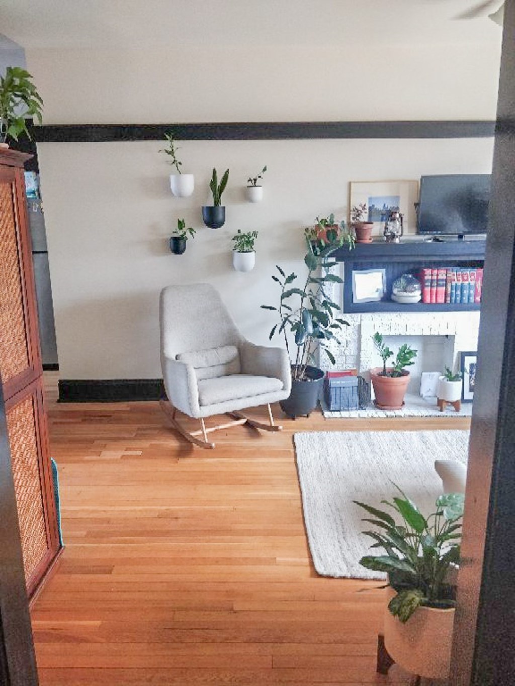 A living room with a white chair and a white rug.