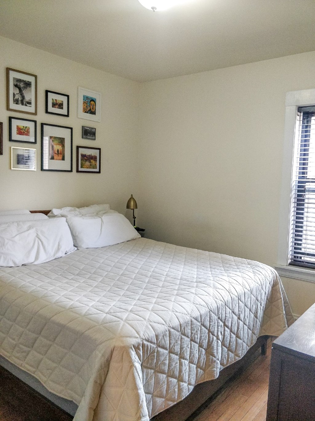 A bed with a white comforter and pillows is in the room.